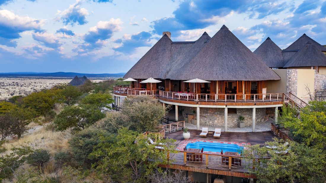 Le bâtiment principal au toit de chaume de l'Etosha Mountain Lodge, avec sa terrasse surélevée surplombant la piscine