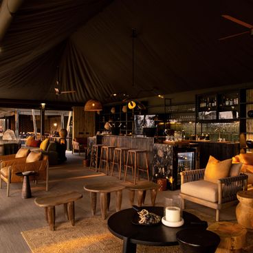 Luxurious lounge and bar area at North Island Okavango lodge featuring elegant safari-style furnishings and ambient lighting