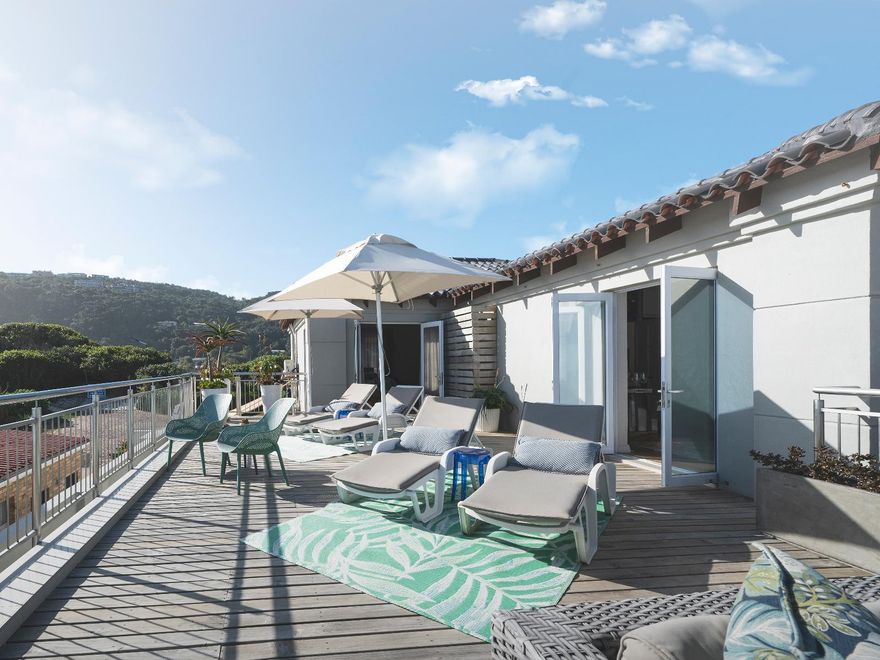 Luxuriöse Suite mit Balkon, Liegestühlen und Blick auf die Berge im Beach Villa Wilderness Resort